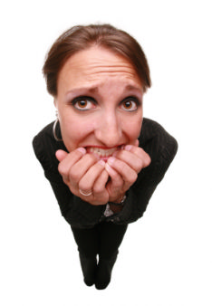 The photo shows a woman biting her nails as she is nervous when preparing for her new job interview.